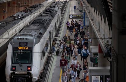 Pasajeros al lado de un tren cercano en la estación de Santa Jeta en Sevilla, este lunes. 