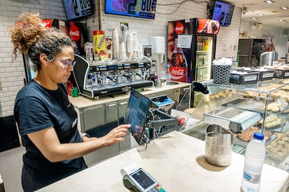 Una mujer saca una factura en un establecimiento de restauración en Barcelona. 
