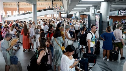 Viajeros aguardan la salida de su tren en la Estación de Atocha, en Madrid, este martes.