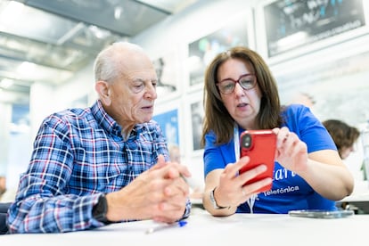 Un voluntario de Reconectados enseña a usar el móvil a un mayor.