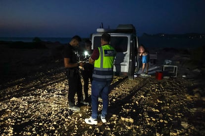 Una pareja de policías locales de San José y un inspector de Transportes del Consell comprueban los permisos de una caravana en Torre D'en Rovira.