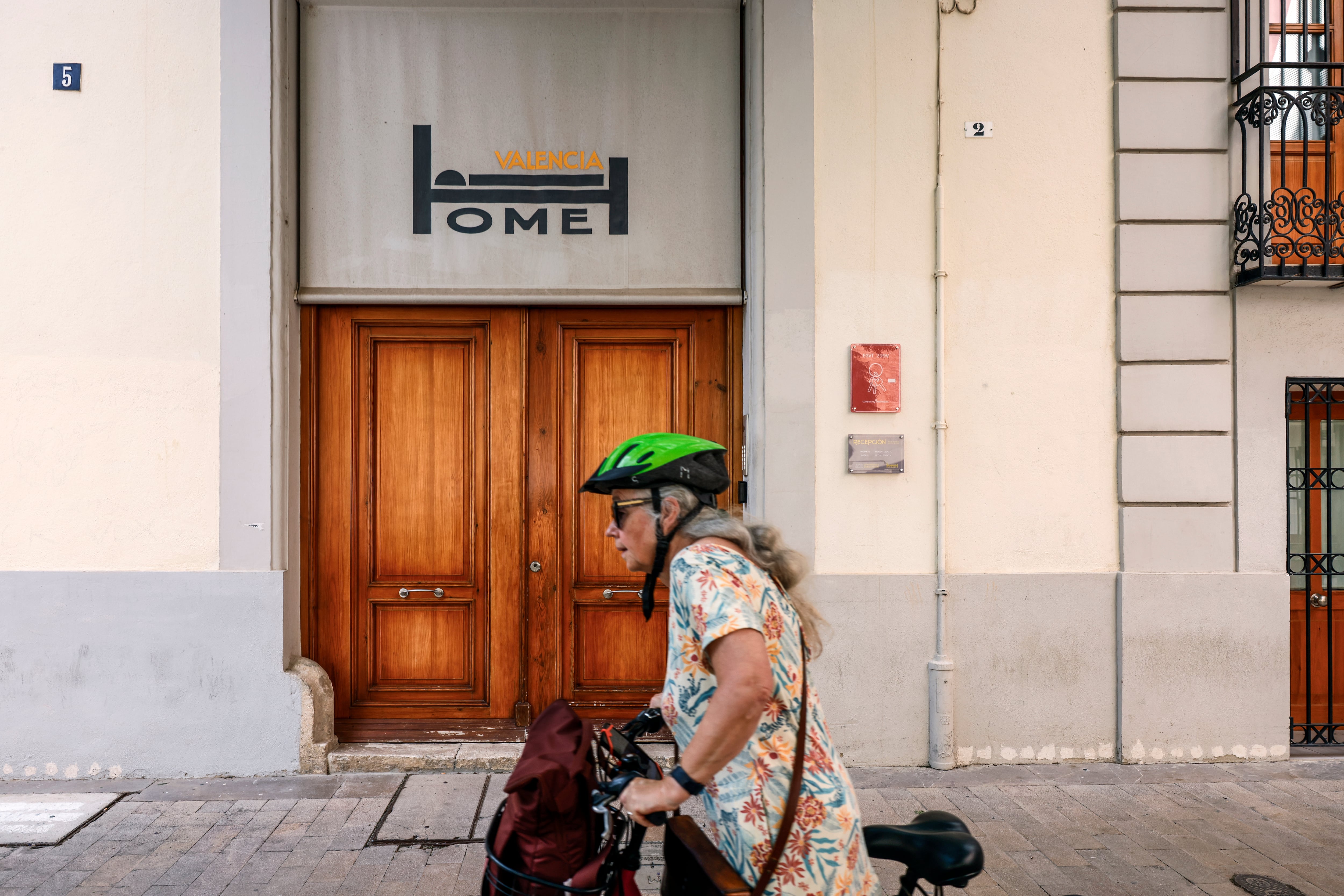 Una mujer pasa por delante de un edificio de Valencia. 