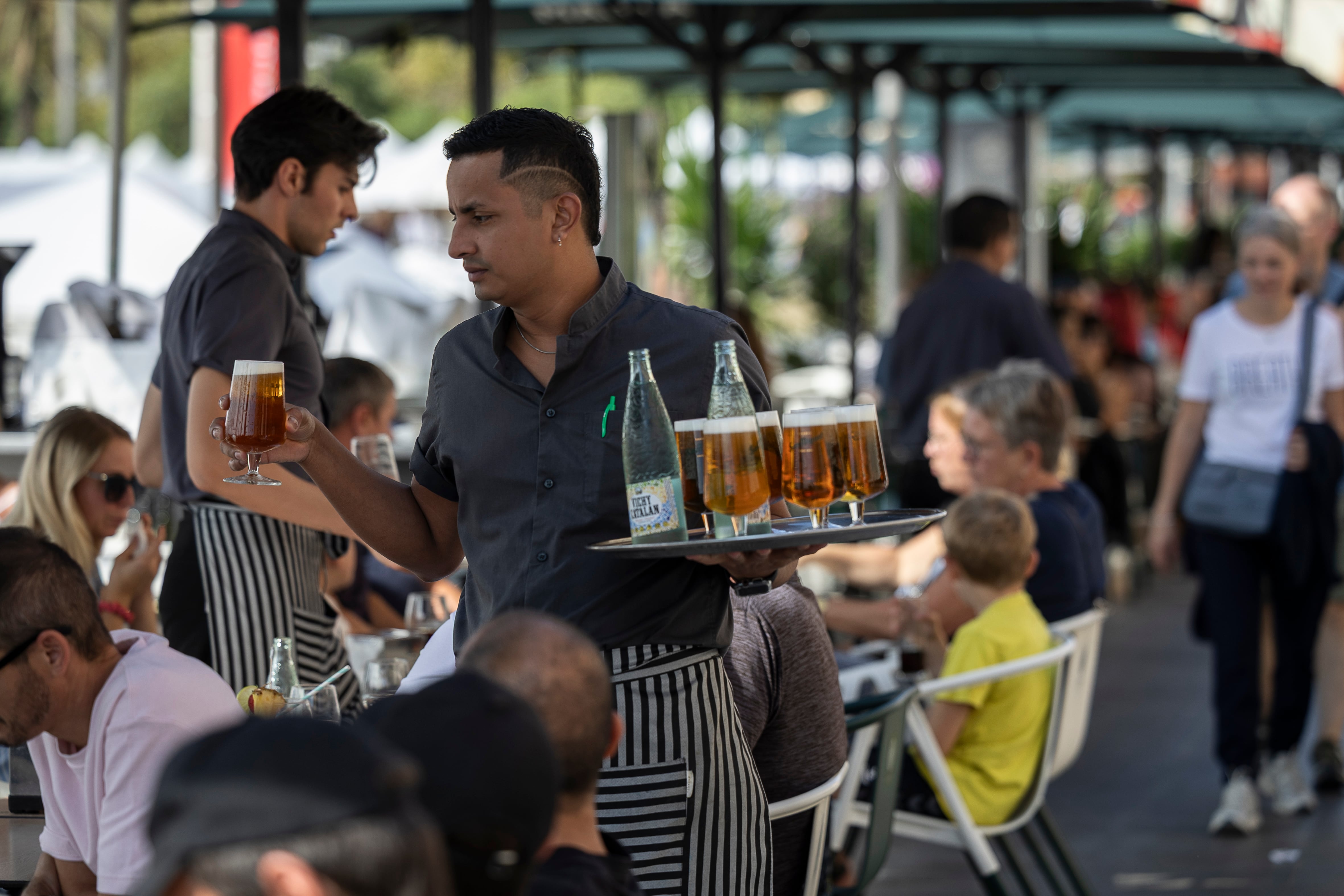 Un camarero transporta una bandeja llena de cervezas, en octubre de 2025.