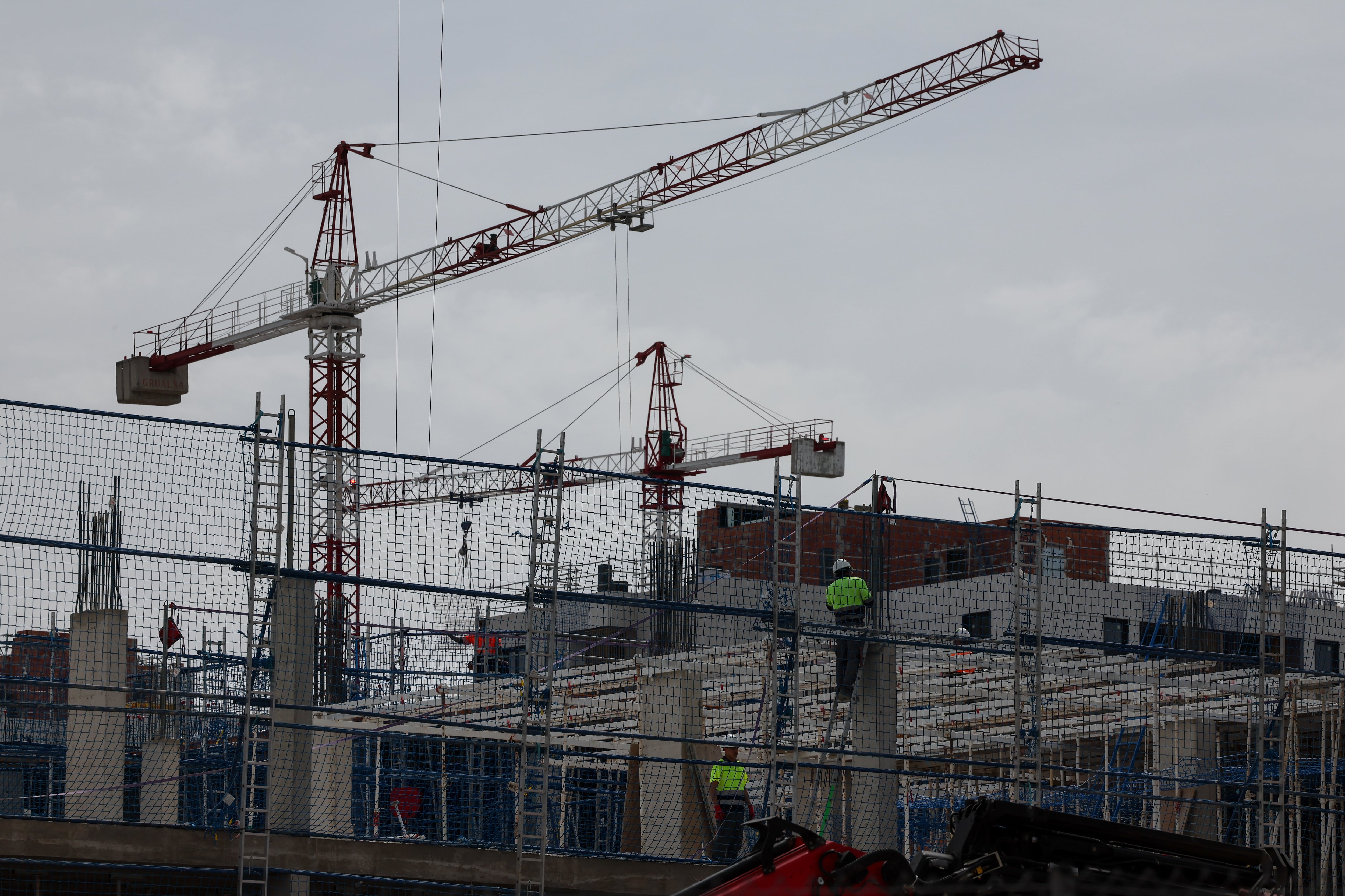 Varios operarios trabajan en la construcción de viviendas en Valdebebas (Madrid). 