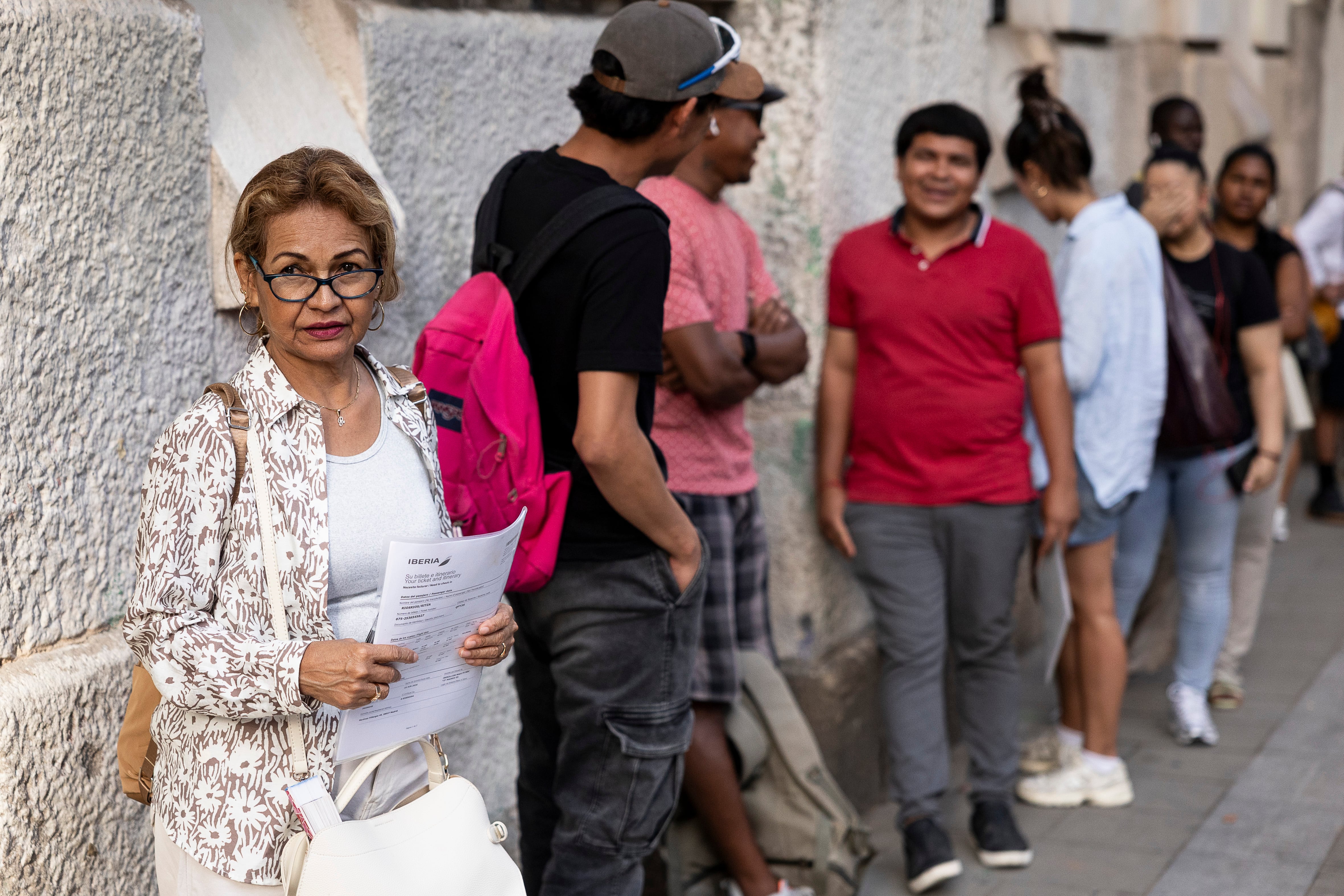 Varias personas esperan turno para acogerse al proceso extraordinario de regularización de migrantes del Gobierno en el exterior del Ayuntamiento de Barcelona. 

