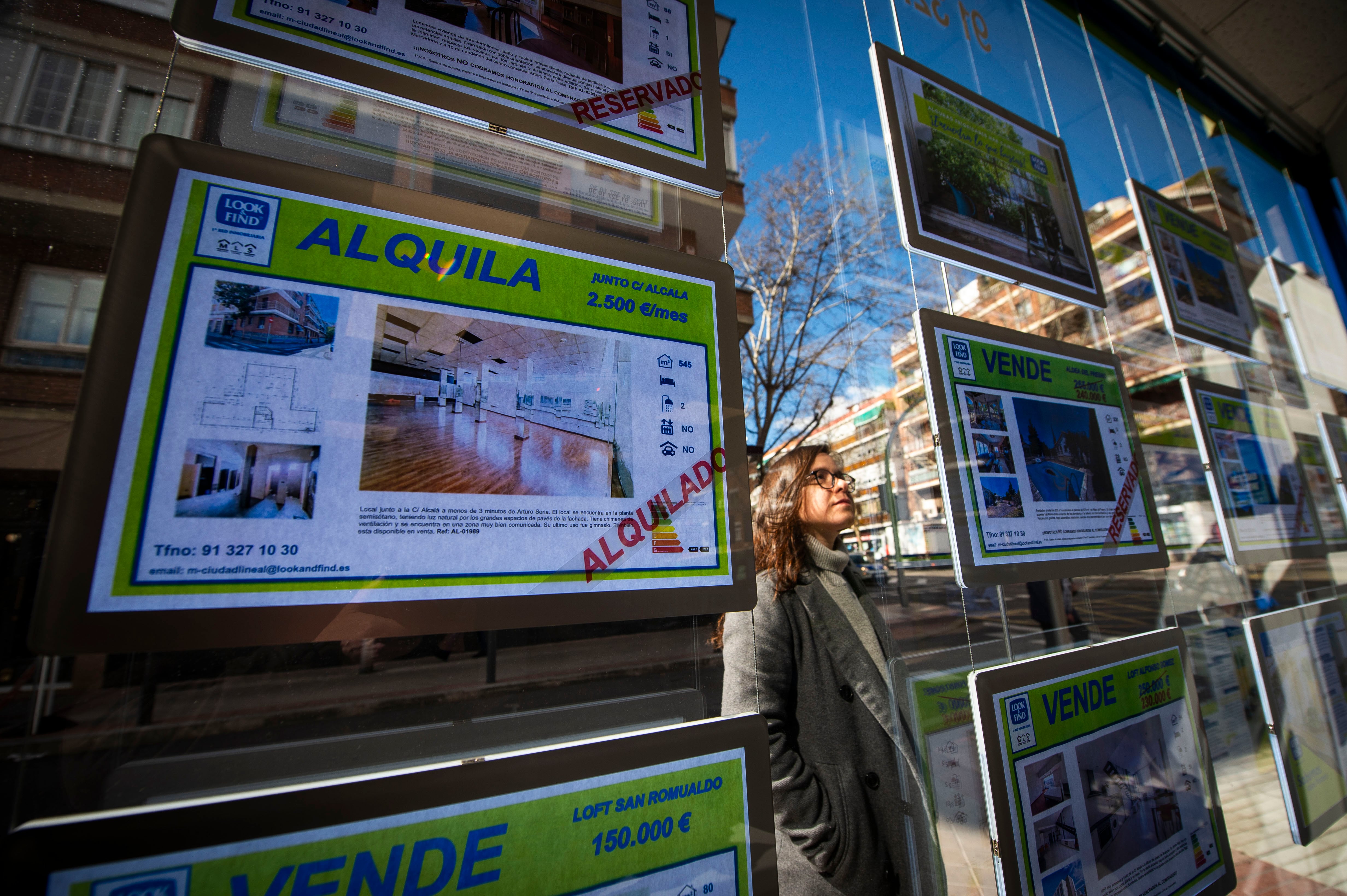 Una mujer observa el escaparate de una inmobiliaria en Madrid.